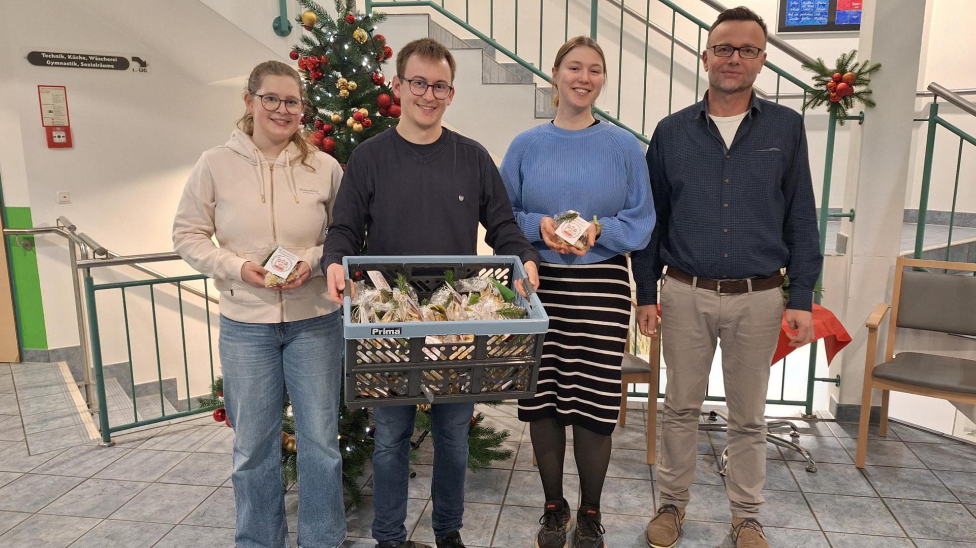 Übergabe der Kekstütchen im Roetgener Seniorenzentrum, 05.12.2025 (v.l.n.r. Messdienerteam Roetgen: Fiona Eckert, Jens Sprotten, Isabel Alpmann u. Residenzleitung Hr. Leesch) (c) J. Sprotten